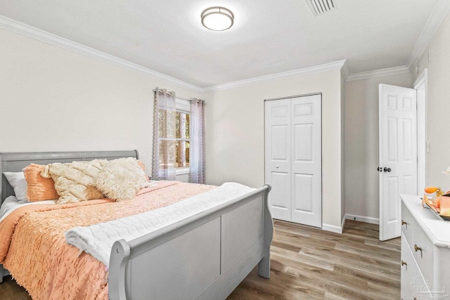 bedroom with dark hardwood / wood-style floors, ornamental molding, and a closet