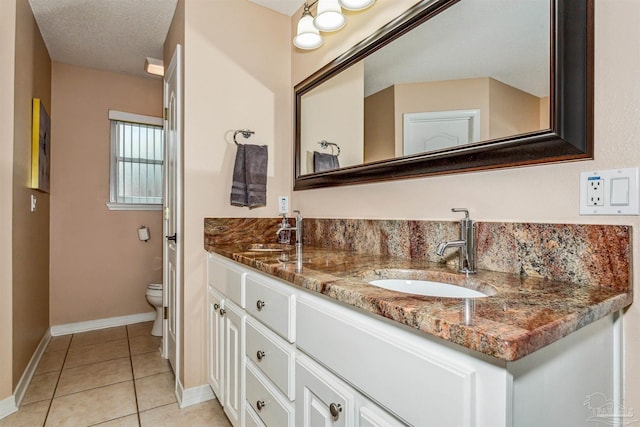 bathroom featuring toilet, vanity, a textured ceiling, and tile patterned flooring