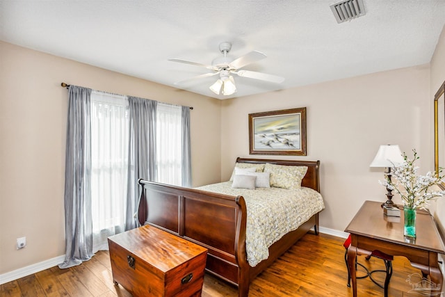 bedroom featuring wood-type flooring, ceiling fan, and a textured ceiling