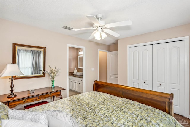 bedroom with ensuite bath, hardwood / wood-style floors, a textured ceiling, ceiling fan, and a closet