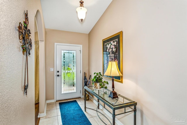 doorway featuring lofted ceiling and light tile patterned flooring