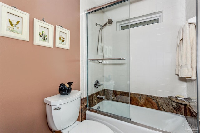 bathroom with shower / bath combination with glass door and toilet