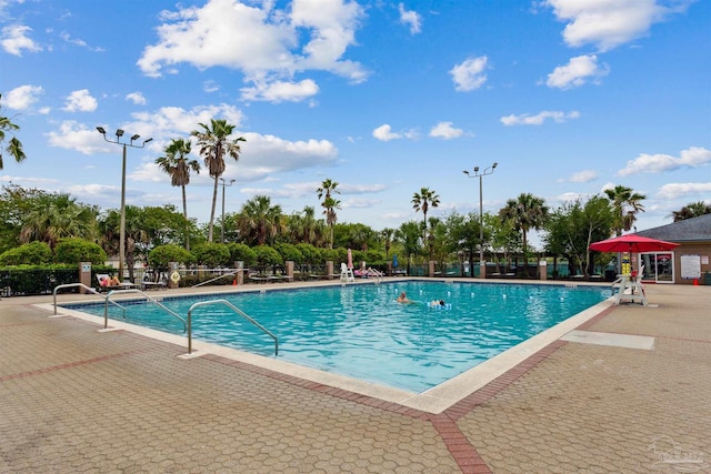 community pool with a patio and fence