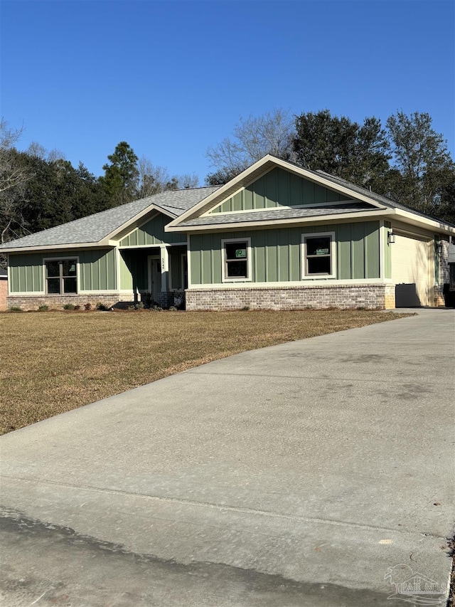 craftsman house featuring brick siding, driveway, roof with shingles, a front lawn, and board and batten siding