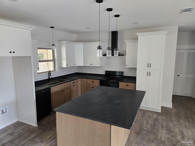 kitchen featuring visible vents, dark countertops, wall chimney range hood, black appliances, and a sink