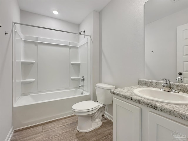 full bath featuring baseboards, toilet, wood finished floors, vanity, and  shower combination