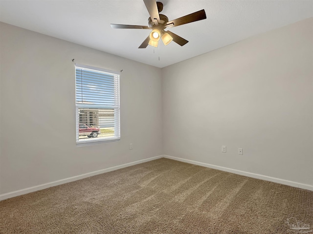 carpeted spare room with baseboards and ceiling fan