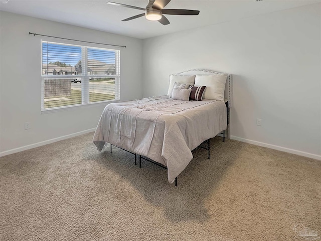 carpeted bedroom featuring baseboards and a ceiling fan