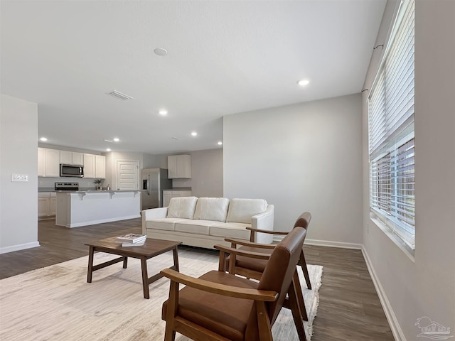 living room with visible vents, recessed lighting, baseboards, and wood finished floors