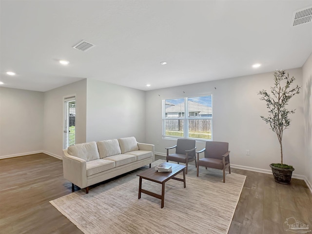 living room with visible vents, plenty of natural light, and wood finished floors