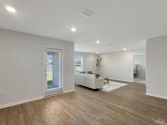 unfurnished living room featuring recessed lighting, visible vents, baseboards, and wood finished floors