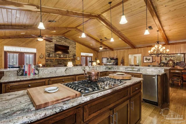 kitchen featuring kitchen peninsula, decorative light fixtures, stainless steel gas cooktop, and wooden ceiling