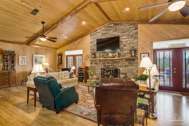 living room featuring wooden ceiling, light hardwood / wood-style flooring, lofted ceiling with beams, wooden walls, and a fireplace