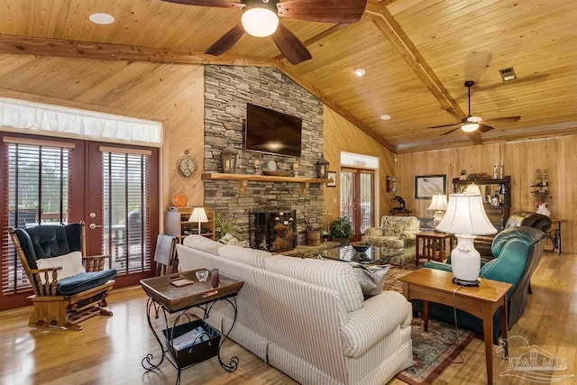 living room featuring beamed ceiling, light hardwood / wood-style floors, wood ceiling, and french doors