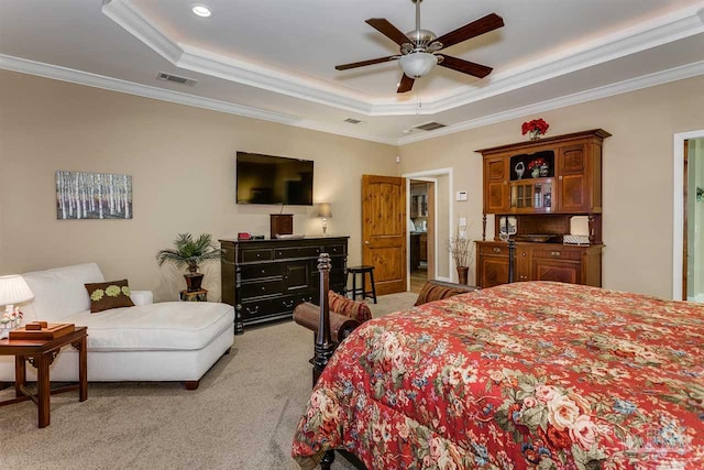 carpeted bedroom with ceiling fan, ornamental molding, and a tray ceiling