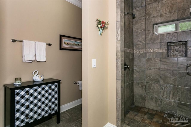 bathroom with ornamental molding and tiled shower