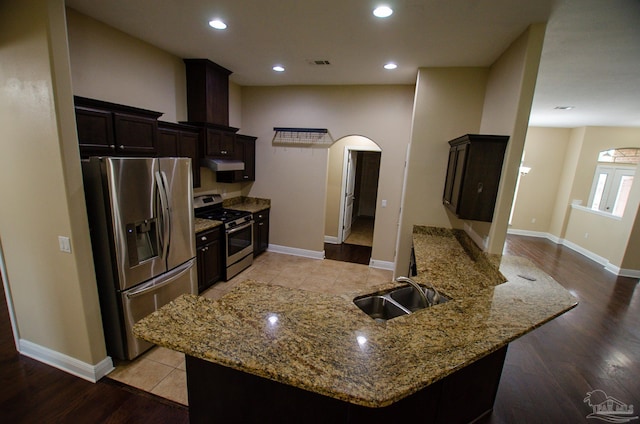 4777 Belvedere Cir, Pace, FL 32571 - kitchen featuring stainless steel appliances, arched walkways, a sink, under cabinet range hood, and light stone counters