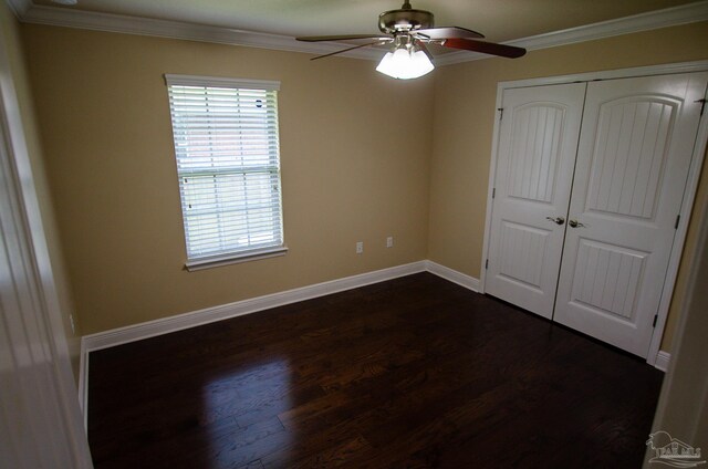 4777 Belvedere Cir, Pace, FL 32571 - unfurnished bedroom featuring dark wood-style flooring, crown molding, a closet, baseboards, and a ceiling fan