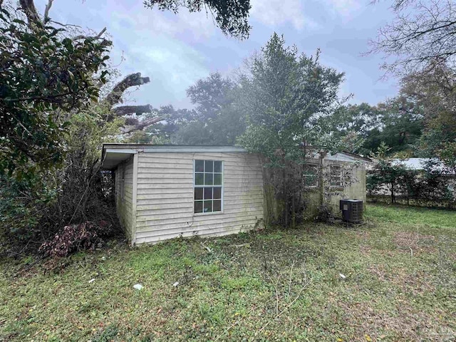 view of side of property with a lawn and cooling unit