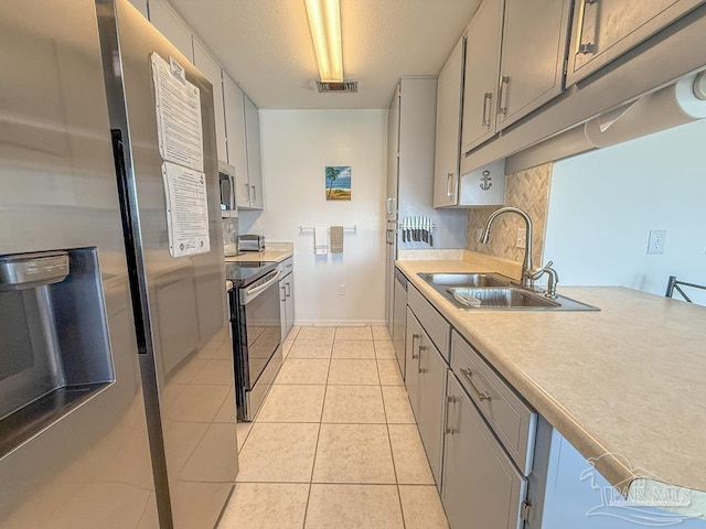 1448 Tina Dr Unit 213, Navarre Beach, FL 32566 - kitchen featuring a sink, appliances with stainless steel finishes, tasteful backsplash, light countertops, and light tile patterned floors