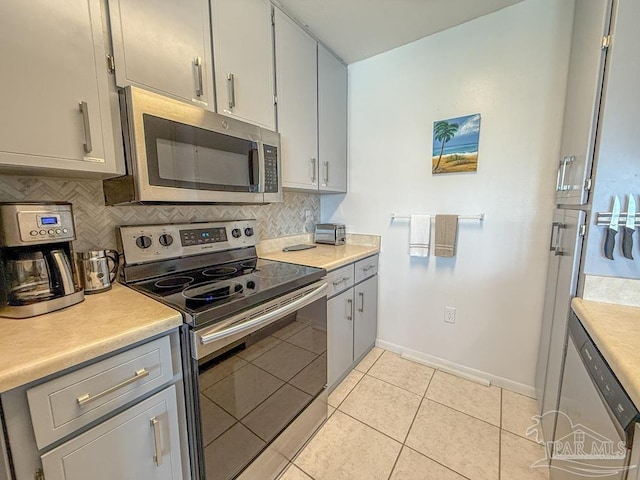 1448 Tina Dr Unit 213, Navarre Beach, FL 32566 - kitchen featuring stainless steel appliances, light countertops, decorative backsplash, and baseboards