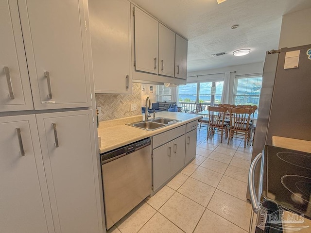 1448 Tina Dr Unit 213, Navarre Beach, FL 32566 - kitchen with stainless steel dishwasher, a sink, range, light countertops, and light tile patterned floors