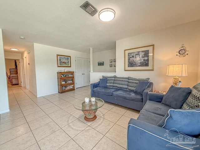1448 Tina Dr Unit 213, Navarre Beach, FL 32566 - living room with light tile patterned floors, a textured ceiling, and baseboards