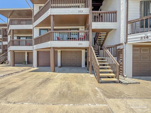 1448 Tina Dr Unit 213, Navarre Beach, FL 32566 - view of building exterior featuring stairs, a garage, and driveway