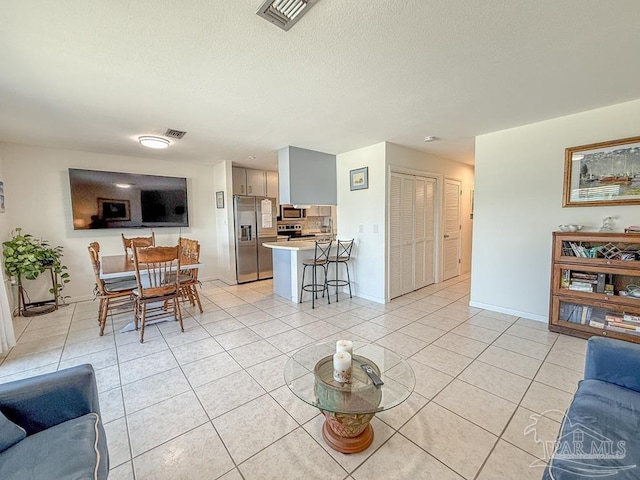 1448 Tina Dr Unit 213, Navarre Beach, FL 32566 - living area featuring light tile patterned floors, baseboards, and a textured ceiling