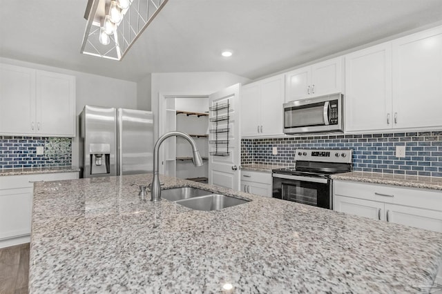 5457 Merlin Way, Milton, FL 32583 - kitchen with stainless steel appliances, a sink, tasteful backsplash, white cabinetry, and light stone countertops