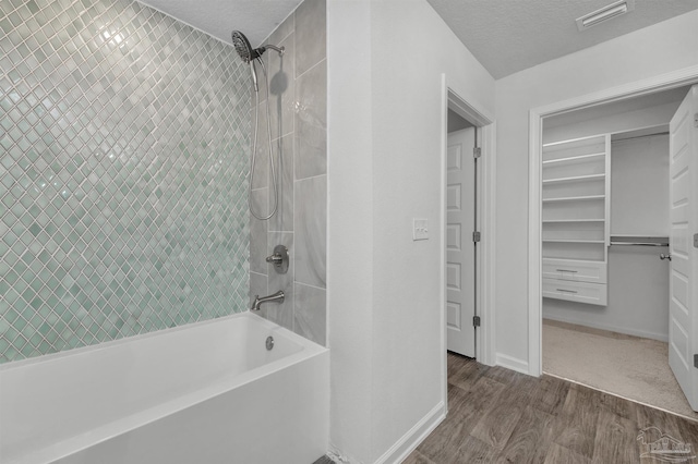 5457 Merlin Way, Milton, FL 32583 - bathroom with shower / tub combination, wood finished floors, a textured ceiling, and baseboards
