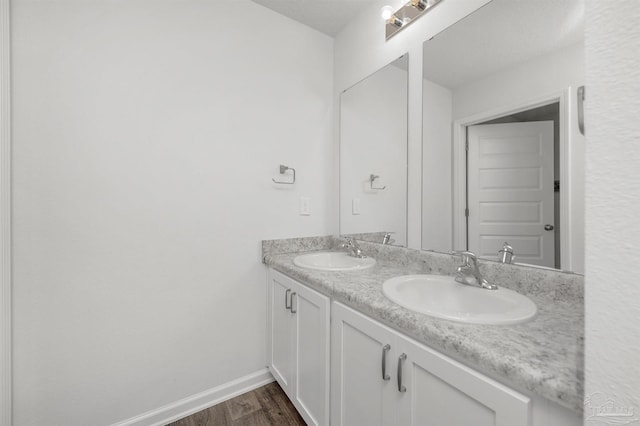 5457 Merlin Way, Milton, FL 32583 - bathroom featuring double vanity, wood finished floors, and baseboards