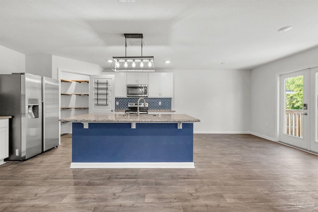 5457 Merlin Way, Milton, FL 32583 - kitchen with appliances with stainless steel finishes, a sink, wood finished floors, backsplash, and a kitchen bar