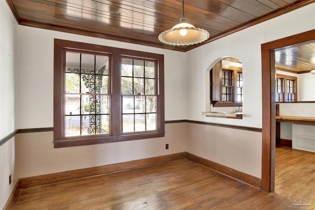 spare room featuring ornamental molding, wood finished floors, and wood ceiling