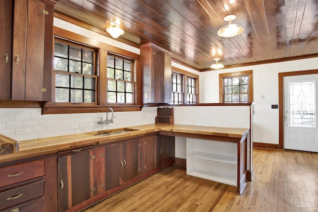 kitchen featuring butcher block counters, backsplash, a sink, and light wood-style flooring