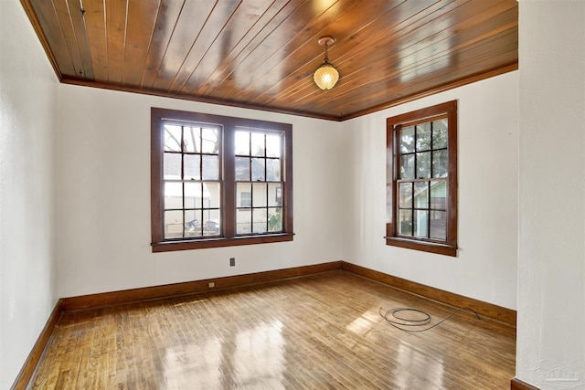 spare room featuring wooden ceiling, baseboards, and wood finished floors