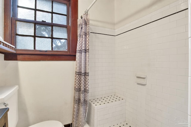 bathroom with toilet and a shower stall