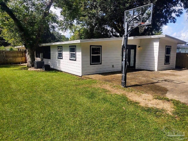 rear view of house featuring a yard and central AC