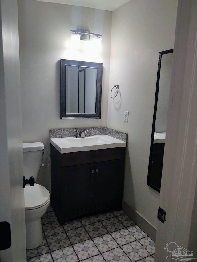 bathroom with tile patterned flooring, vanity, and toilet