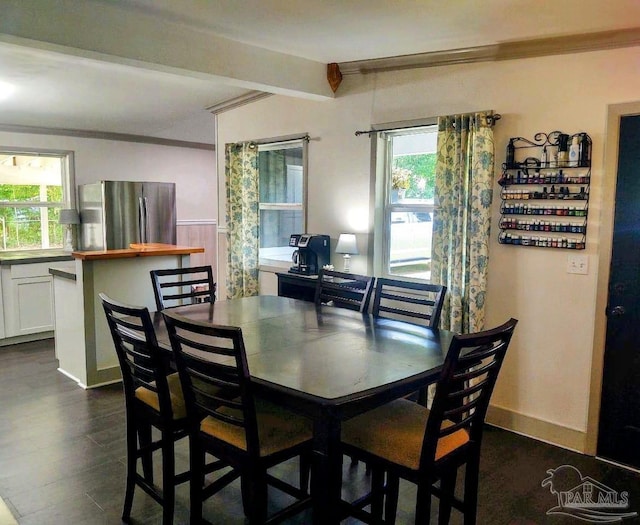 dining room with a wealth of natural light, crown molding, and dark hardwood / wood-style floors