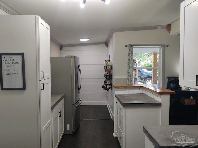 kitchen featuring dark hardwood / wood-style floors, stainless steel fridge, and white cabinets