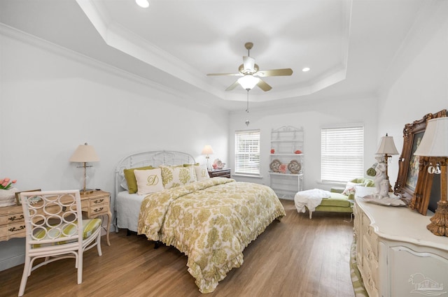 bedroom featuring a raised ceiling, crown molding, hardwood / wood-style flooring, and ceiling fan