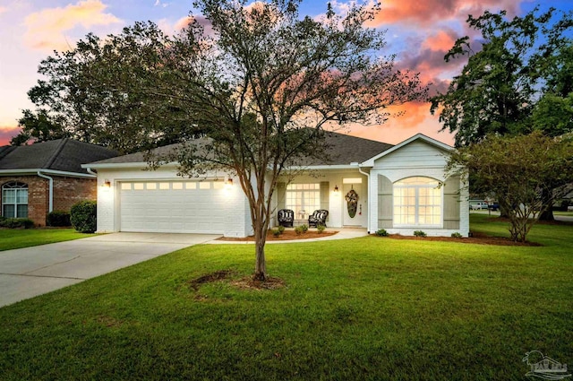 ranch-style home with a garage and a yard