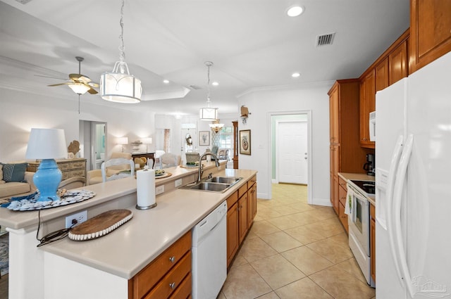 kitchen with pendant lighting, a kitchen island with sink, sink, and white appliances