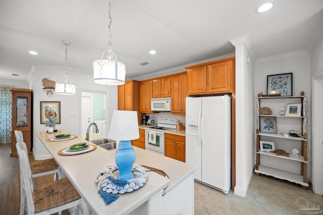 kitchen with a center island with sink, pendant lighting, white appliances, and light tile patterned flooring