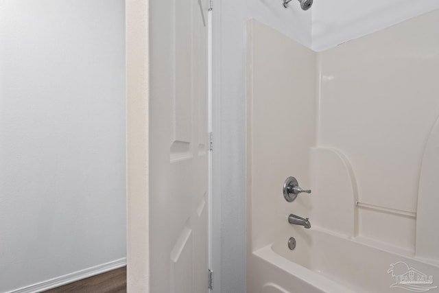 bathroom featuring shower / tub combination and baseboards