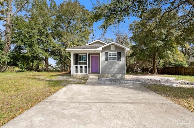 view of front facade with covered porch, fence, and a front yard