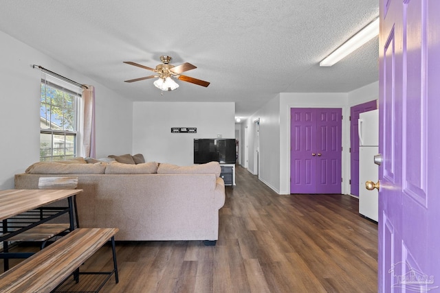 living area featuring a textured ceiling, a ceiling fan, and dark wood-style flooring