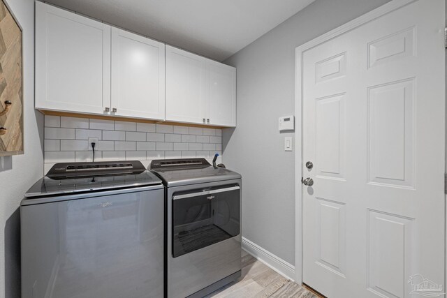 1008 Black Walnut Trl, Pensacola, FL 32514 - laundry room with washer and clothes dryer, cabinet space, baseboards, and light wood-type flooring