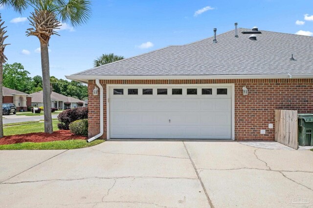 1008 Black Walnut Trl, Pensacola, FL 32514 - view of side of home featuring brick siding, a shingled roof, concrete driveway, and a garage